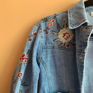 Short jean jacket with stitched flower detailing.